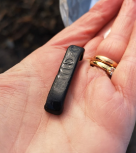 A piece of sea washed plastic A Whitby Jet collector hold a piece of black plastic in their hand