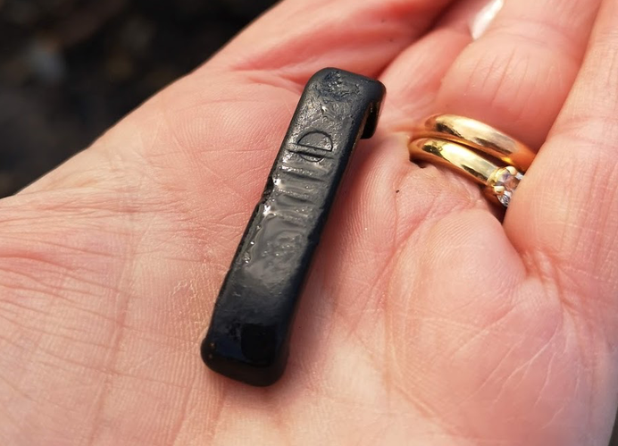 Whitby Jet collector holding a piece of black plastic in hand